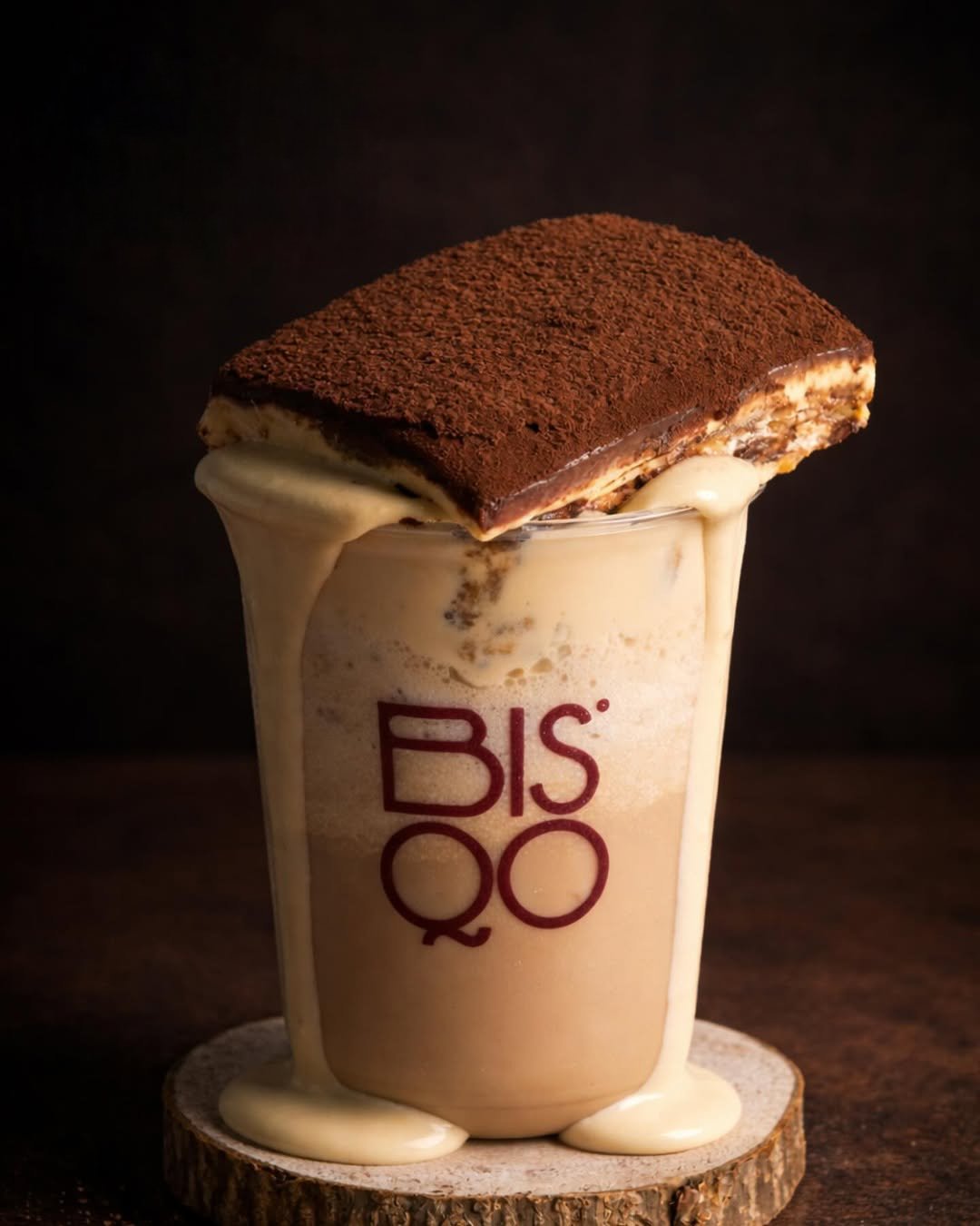 A cup of tiramisu layered with mascarpone and espresso-soaked biscuit, finished with a thick cocoa dusting.