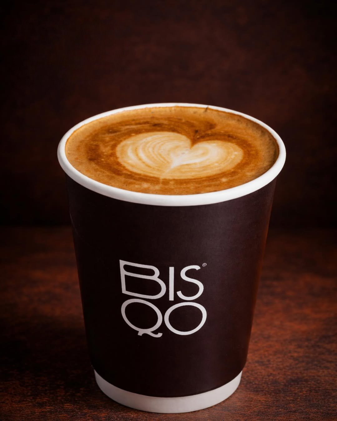 An iced Spanish latte in a clear cup, condensed milk settling through the coffee.