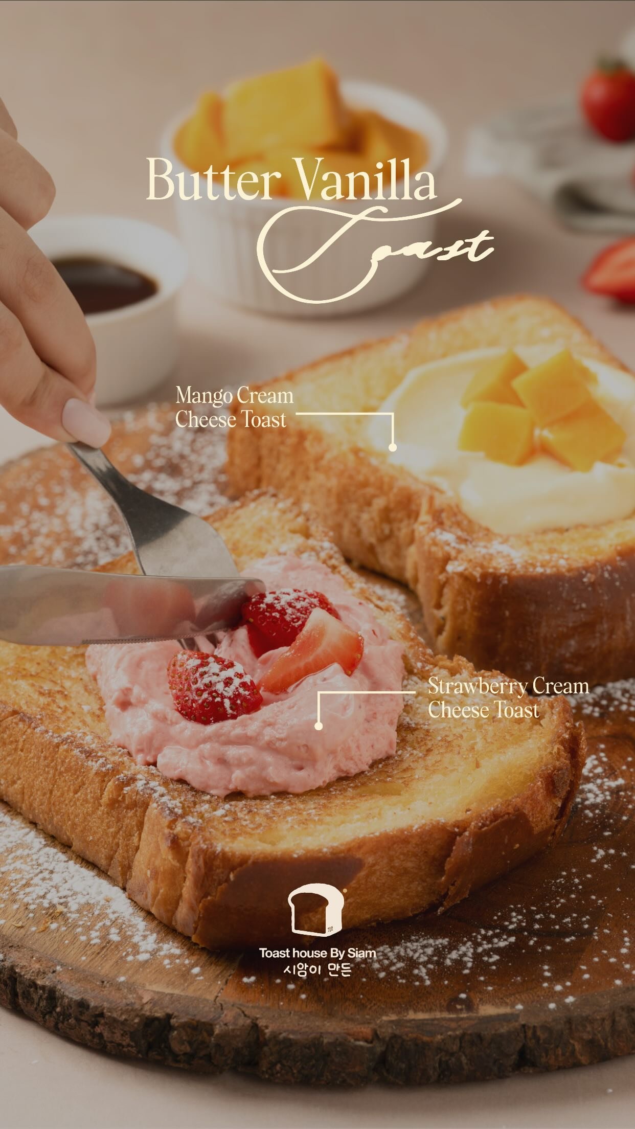 Two thick slices of griddled brioche dusted with icing sugar on a wooden board, one topped with strawberry cream cheese and fresh strawberries, the other with mango cream cheese and mango cubes.