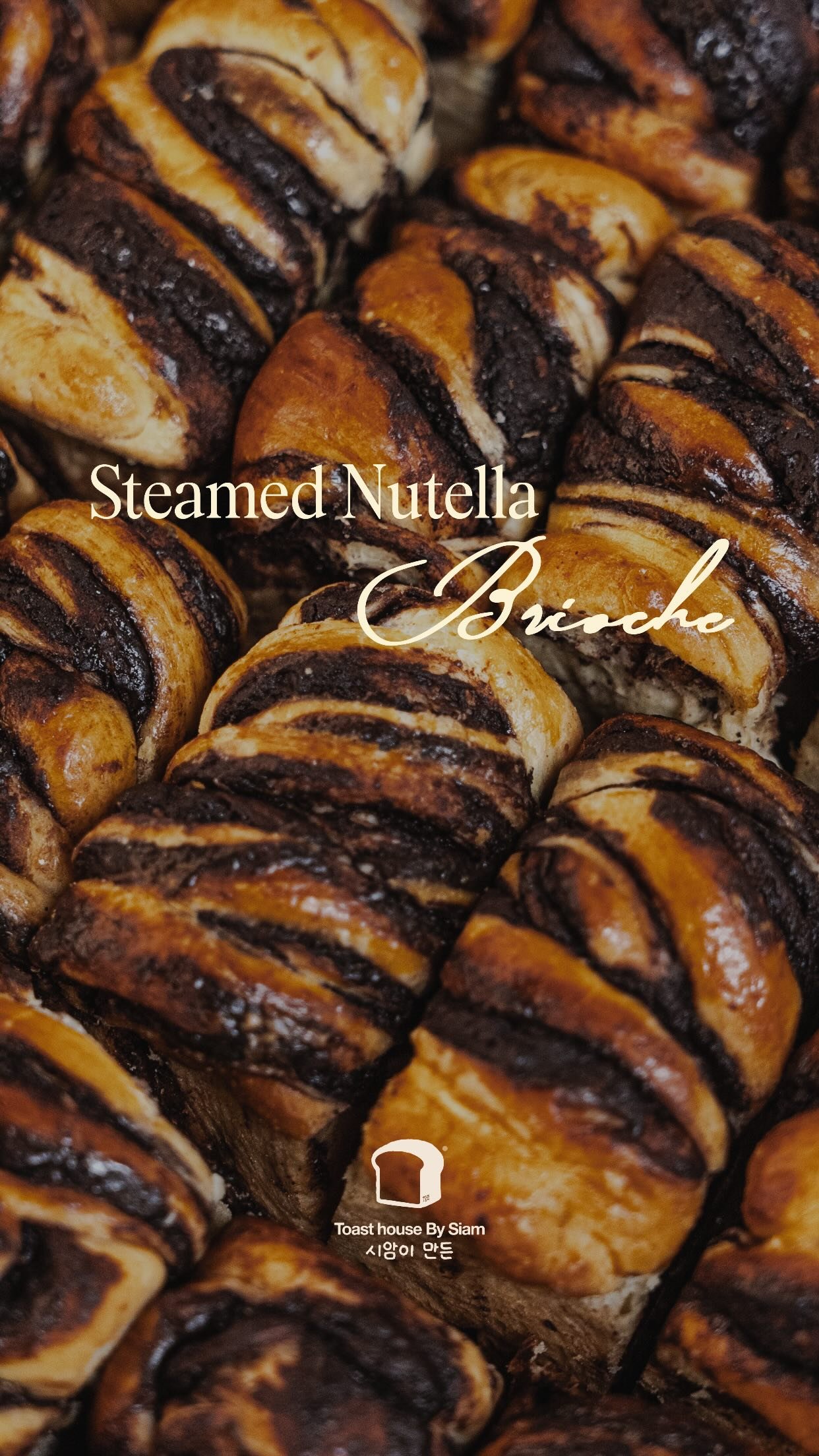 A close tray of steamed brioche rolls swirled through with Nutella, glossy and dark against golden dough.